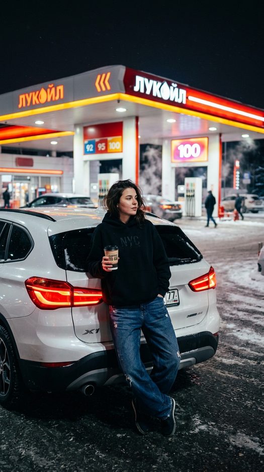 девушка у bmw x1 с кофе на ночной азс зимой