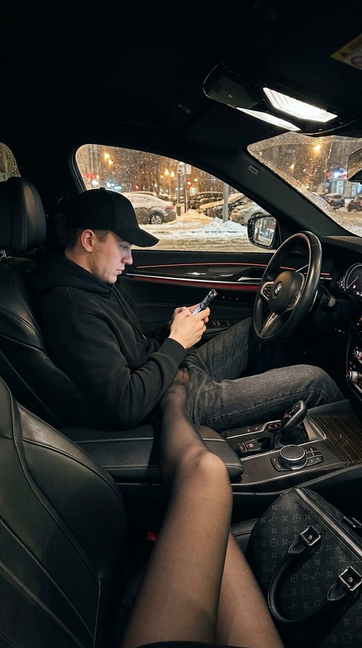 мужчина в bmw ночью со смартфоном