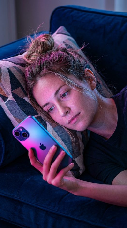 женщина с iphone на синем бархатном диване